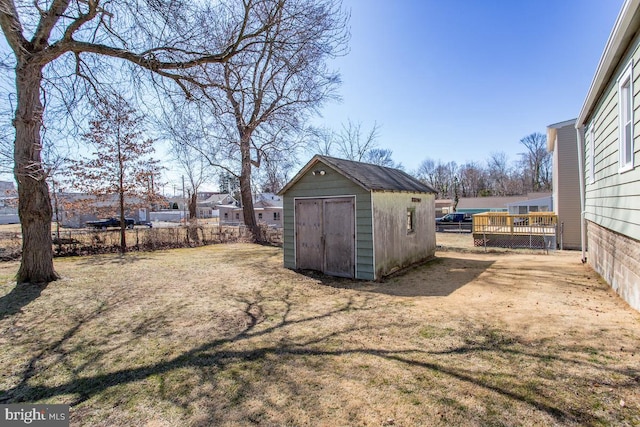 view of yard featuring a storage unit, an outbuilding, and fence