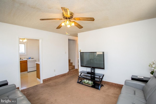 living room with baseboards, light carpet, a textured ceiling, and a ceiling fan