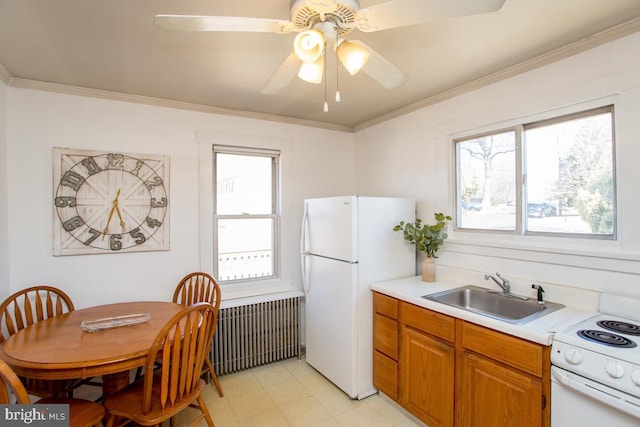 kitchen with crown molding, light countertops, brown cabinets, white appliances, and a sink