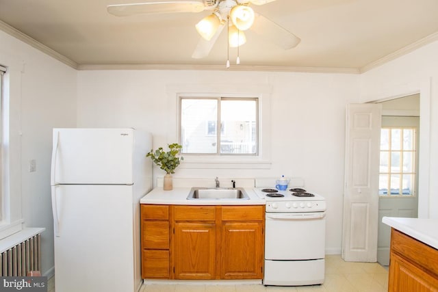 kitchen featuring ornamental molding, white appliances, light countertops, and a sink