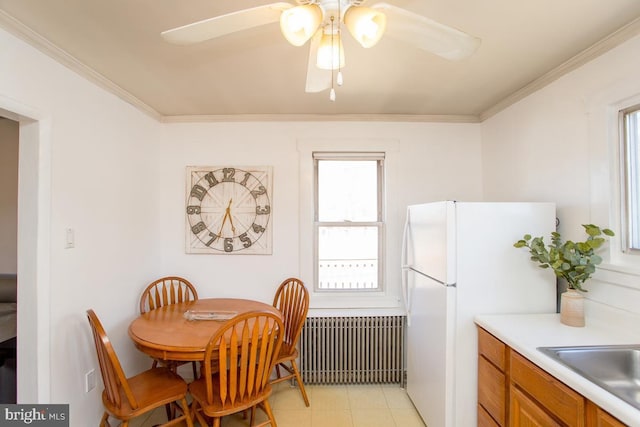 dining space with radiator, ornamental molding, and a ceiling fan