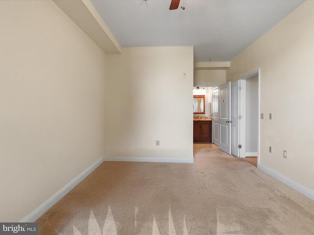 unfurnished room with light colored carpet, baseboards, and ceiling fan