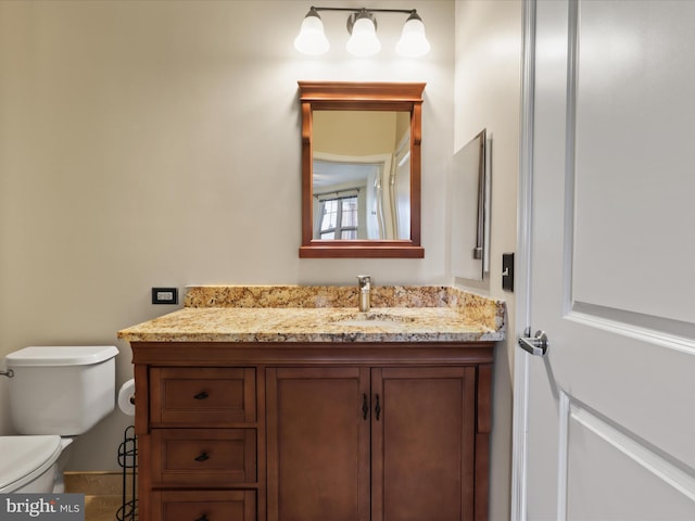 half bathroom with vanity and toilet