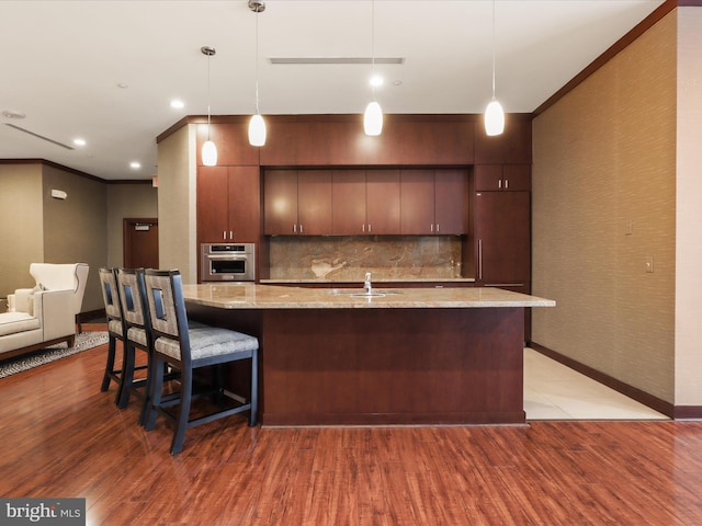 kitchen with a sink, crown molding, light wood-style floors, and stainless steel oven