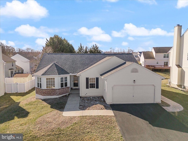 single story home featuring fence, driveway, an attached garage, a front lawn, and brick siding