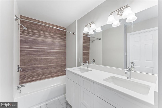 bathroom featuring double vanity, shower / bath combination, marble finish floor, and a sink