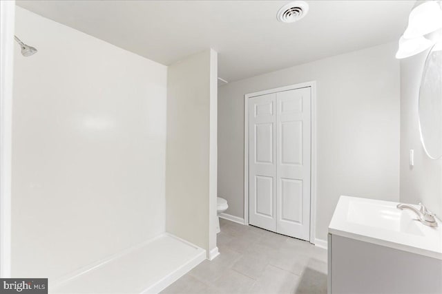 bathroom with vanity, toilet, visible vents, and walk in shower