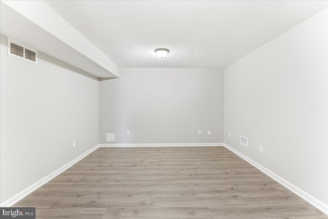 unfurnished room featuring visible vents, baseboards, and light wood-style floors