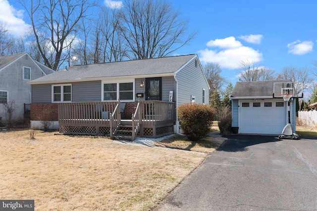 single story home with a front yard, a garage, an outdoor structure, a deck, and driveway