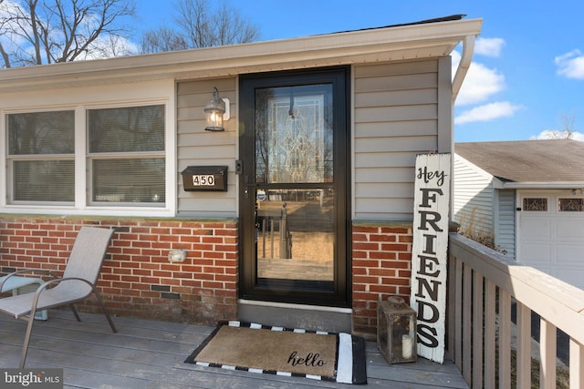 view of exterior entry with brick siding and fence