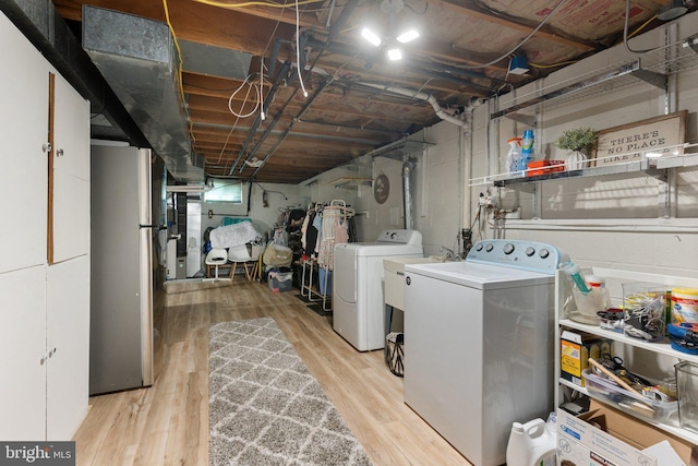 laundry room with separate washer and dryer, wood finished floors, and laundry area