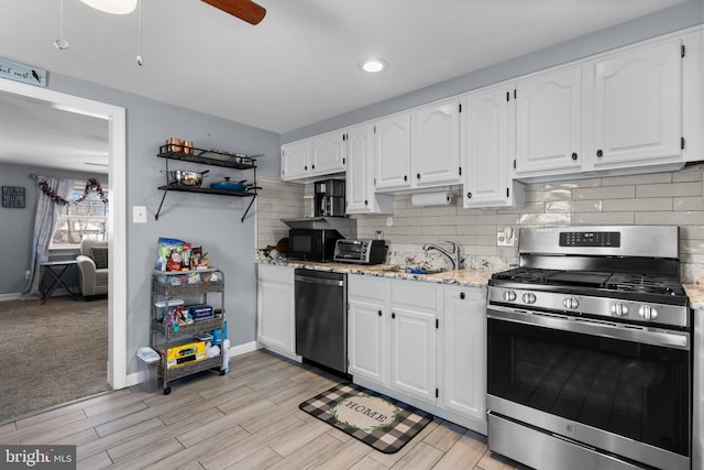 kitchen featuring a sink, white cabinets, light stone countertops, and stainless steel appliances