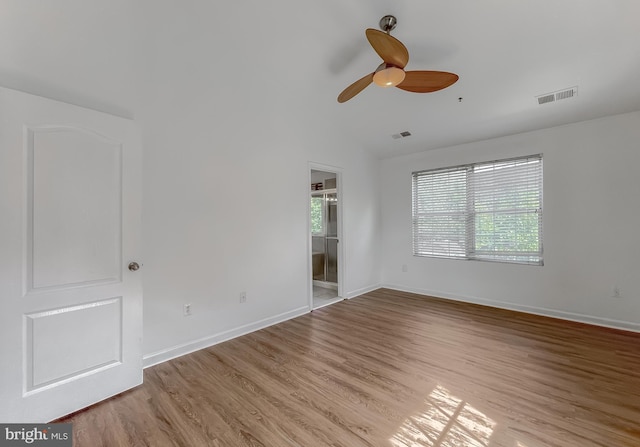 empty room with plenty of natural light, baseboards, and light wood-type flooring