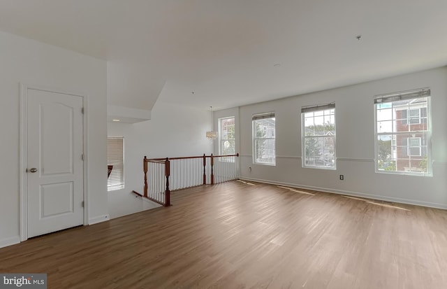 spare room featuring baseboards and wood finished floors