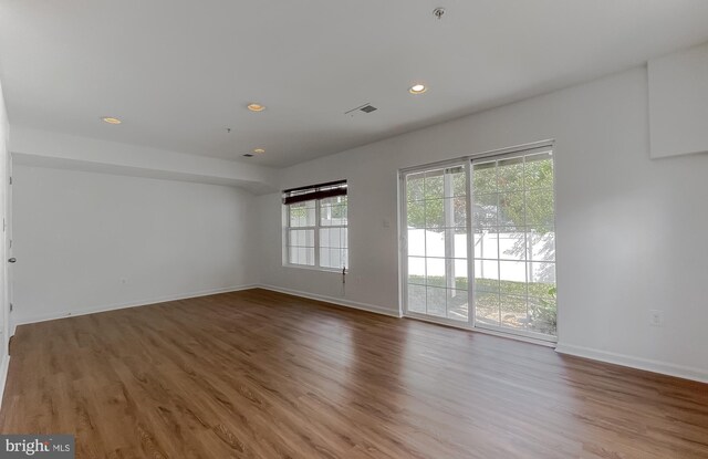 unfurnished room featuring recessed lighting, baseboards, visible vents, and wood finished floors