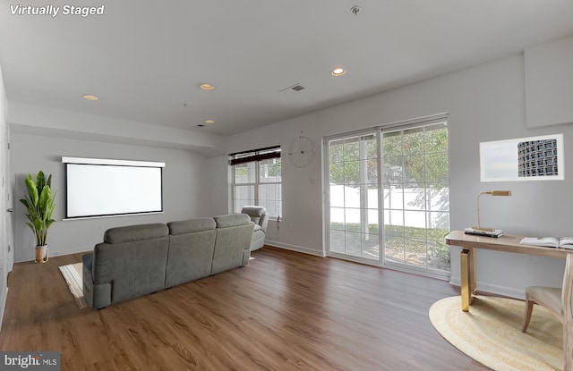 living area with baseboards, visible vents, wood finished floors, and recessed lighting
