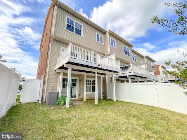 back of property featuring fence, central AC, a deck, and a yard