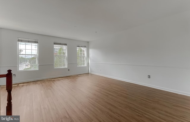 spare room featuring baseboards and wood finished floors