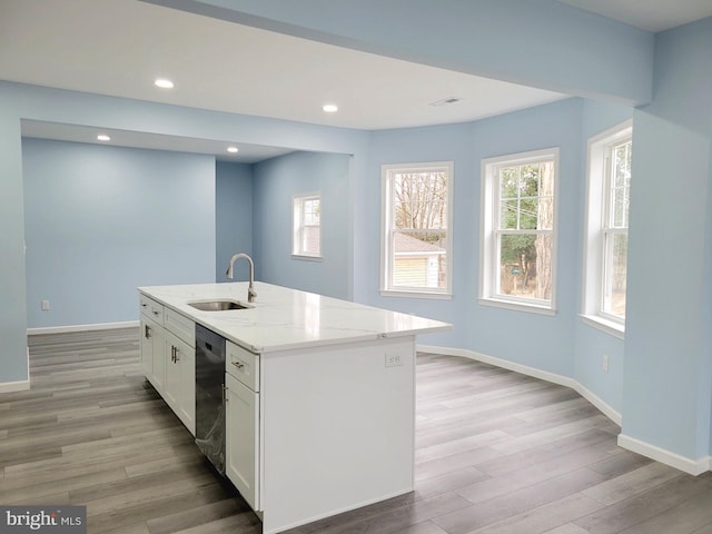 kitchen with dishwashing machine, light wood-style flooring, baseboards, and a sink