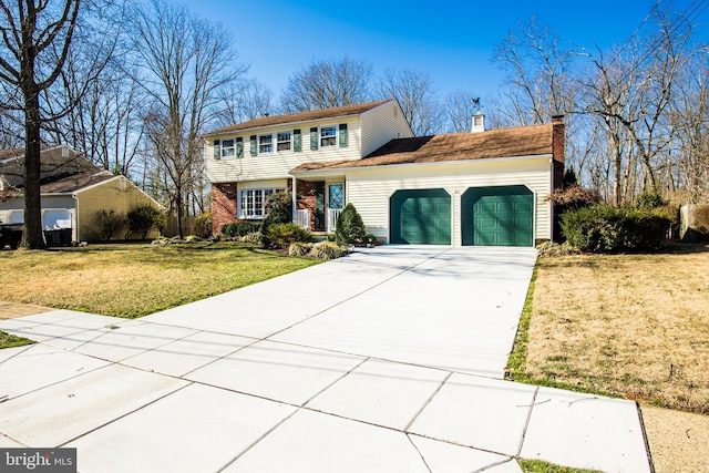 colonial-style house featuring driveway, a chimney, a front lawn, a garage, and brick siding