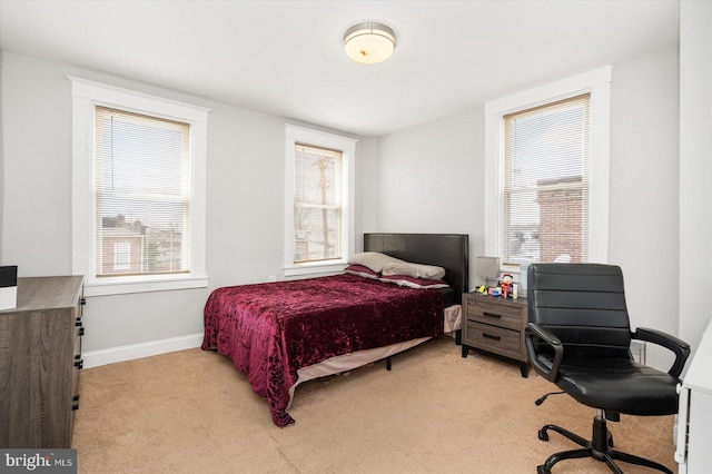 bedroom with baseboards and light carpet