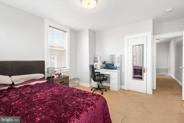 bedroom with light carpet and baseboards