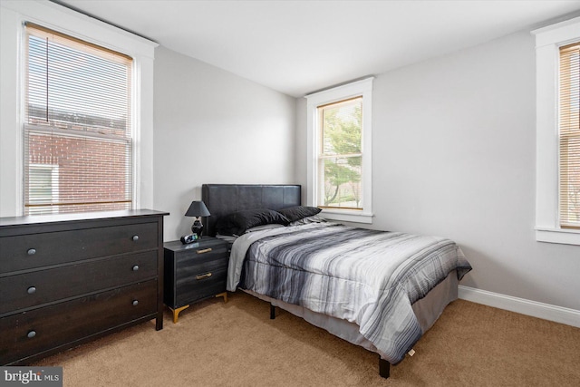 bedroom featuring light colored carpet and baseboards