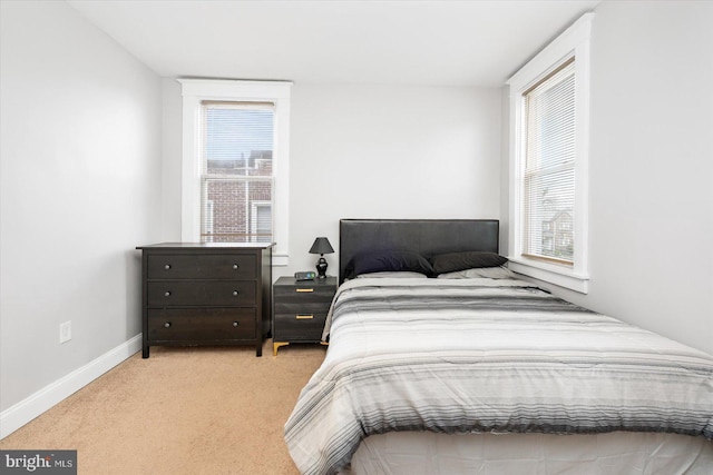 bedroom featuring baseboards and light carpet