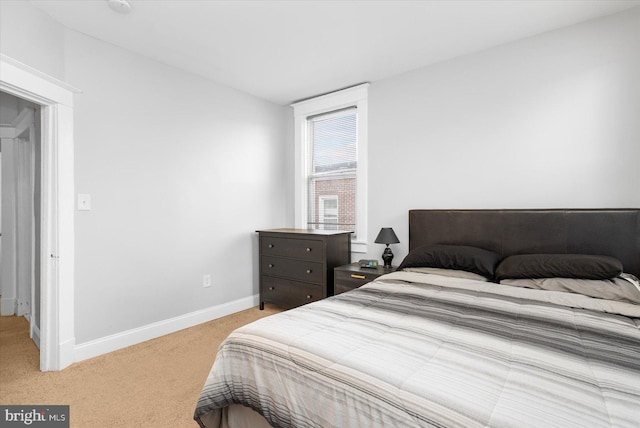 bedroom with light colored carpet and baseboards