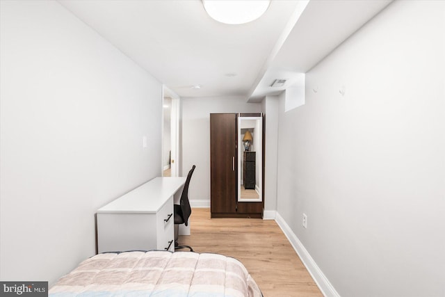 bedroom featuring baseboards, visible vents, and light wood-style flooring
