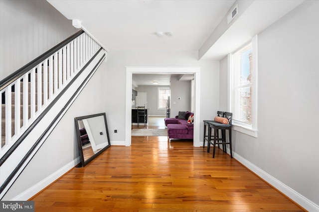 sitting room featuring wood-type flooring, baseboards, stairs, and visible vents