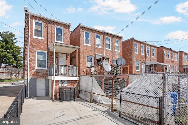view of front facade featuring brick siding, fence, and a gate