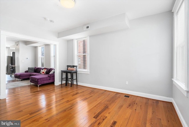 sitting room with baseboards, visible vents, and wood-type flooring