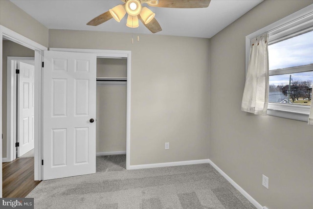 unfurnished bedroom with a closet, carpet flooring, ceiling fan, and baseboards