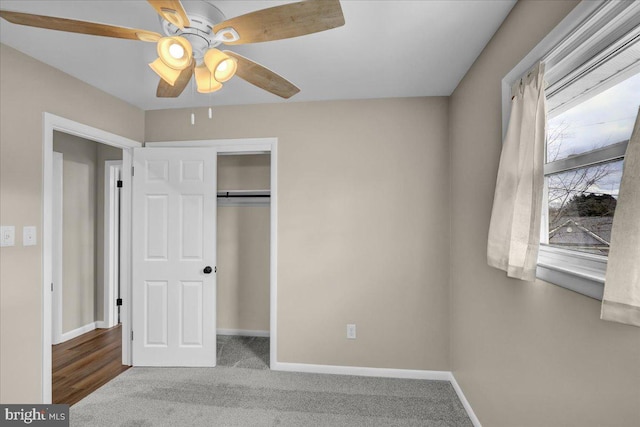 unfurnished bedroom featuring carpet, baseboards, a closet, and ceiling fan