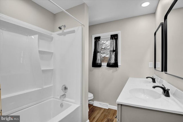 bathroom featuring a sink, visible vents, toilet, and wood finished floors