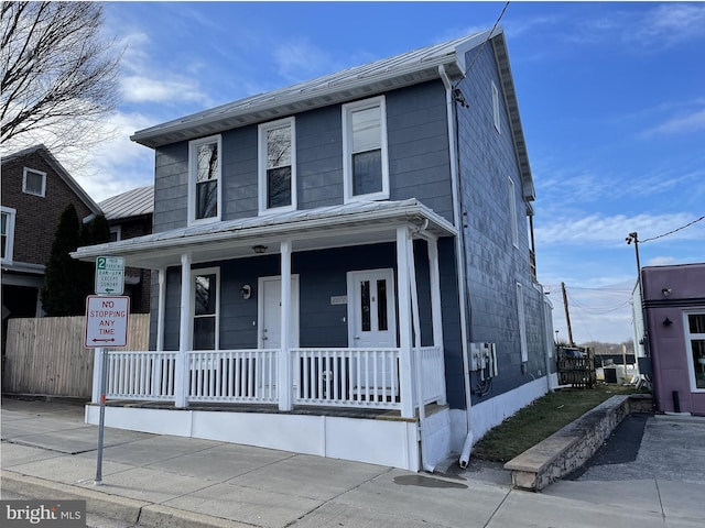 view of front facade featuring covered porch and fence