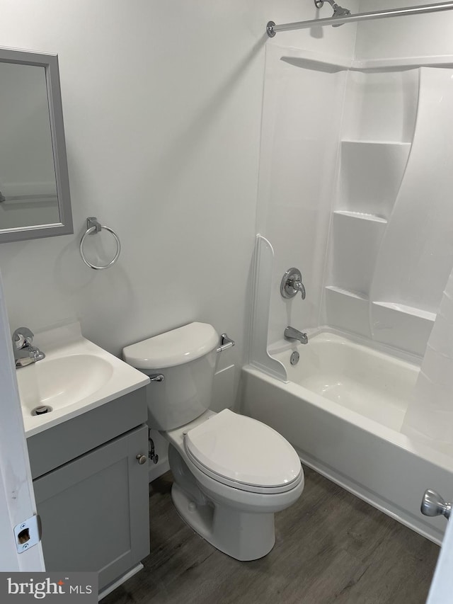 full bath with vanity, toilet, shower / bath combination, and wood finished floors