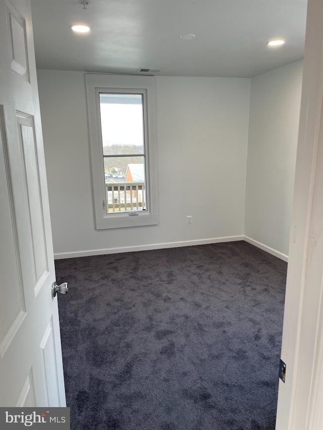 unfurnished room with recessed lighting, visible vents, baseboards, and dark carpet