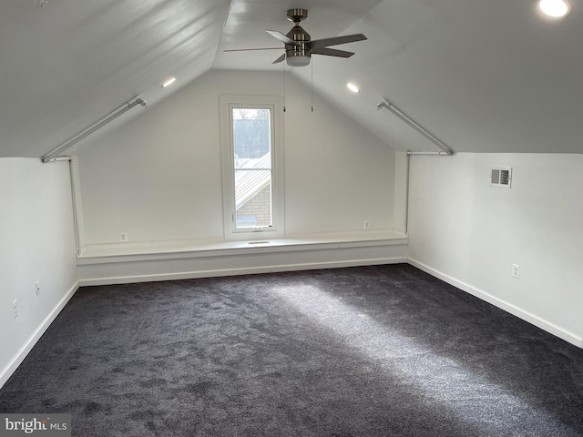 bonus room featuring visible vents, dark carpet, baseboards, and vaulted ceiling