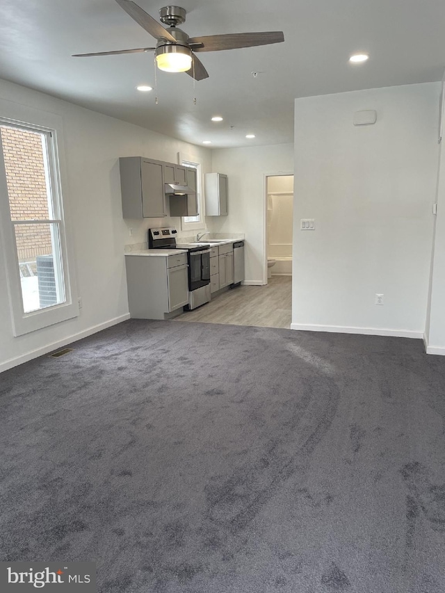 unfurnished living room with recessed lighting, baseboards, and carpet floors