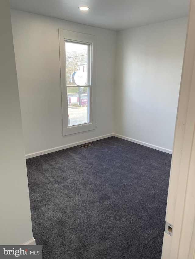 unfurnished room featuring recessed lighting, visible vents, baseboards, and dark colored carpet