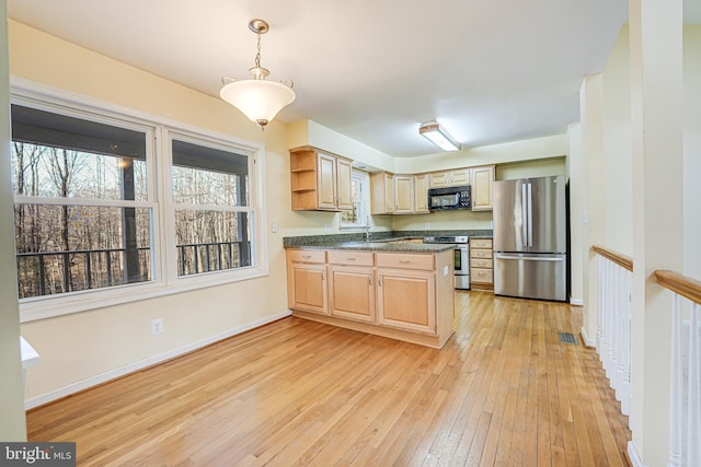 kitchen with light wood-type flooring, open shelves, dark countertops, appliances with stainless steel finishes, and a peninsula