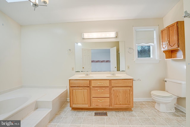 bathroom with double vanity, toilet, a garden tub, and a sink