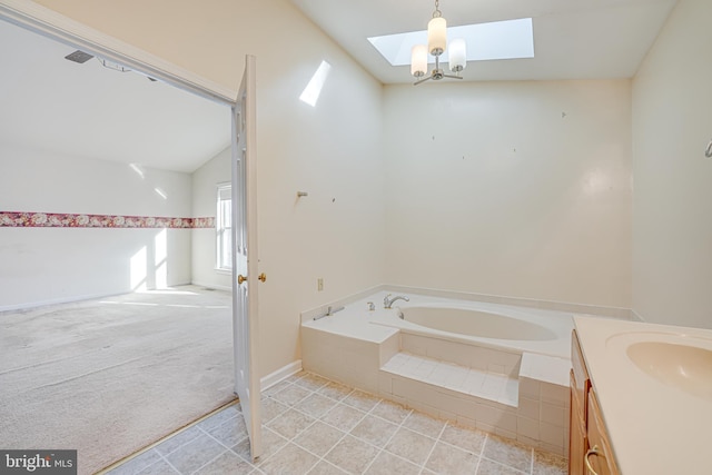 bathroom featuring vanity, lofted ceiling with skylight, a garden tub, and tile patterned floors