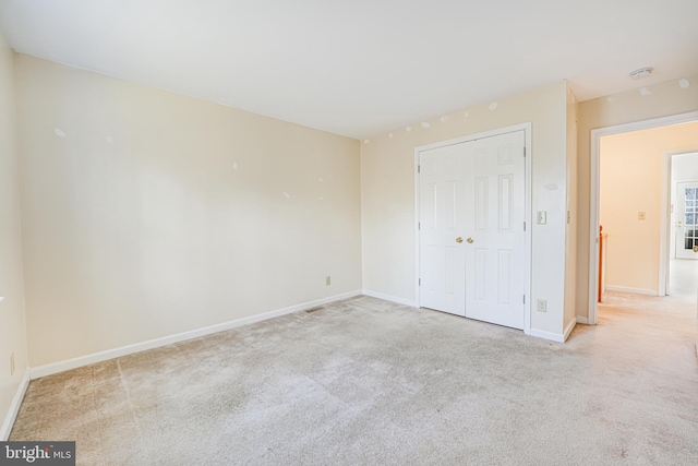 unfurnished bedroom with a closet, baseboards, and carpet