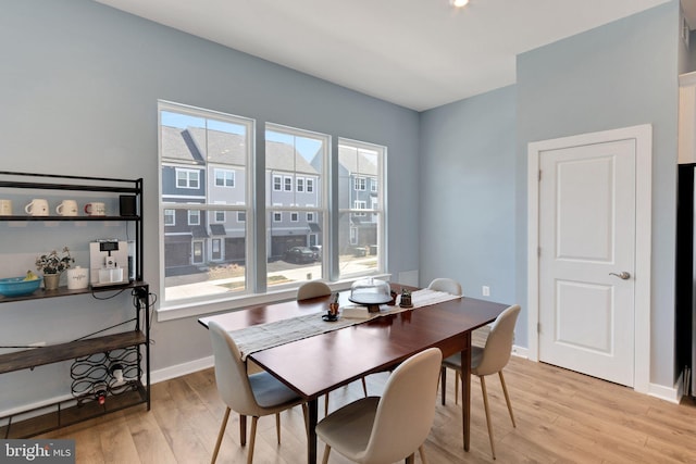 dining area with baseboards and light wood-style floors