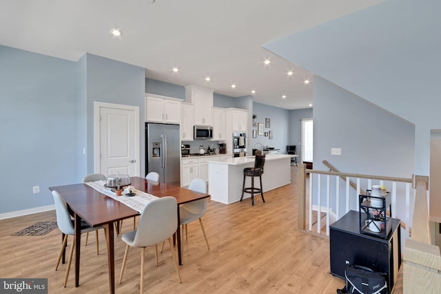 dining space with recessed lighting, baseboards, and light wood finished floors