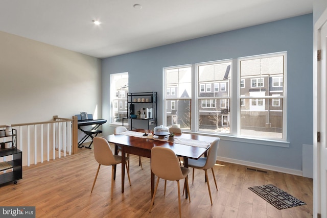 dining space featuring visible vents, baseboards, and wood finished floors