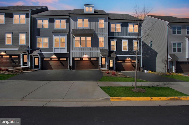 townhome / multi-family property with an attached garage, board and batten siding, and driveway